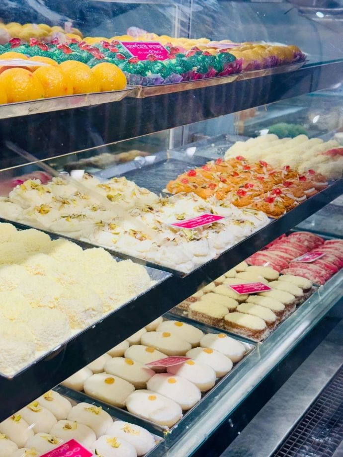 Assortment of colorful indian sweets displayed in a shop.